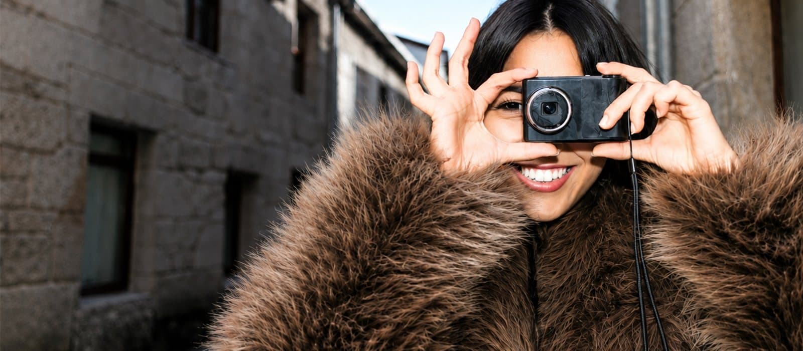 Woman with camera in fur coat